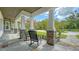 Inviting front porch with stone pillars, classic rocking chairs, and tranquil views of the lush front yard at 6050 Saddle Oak Trl, Sarasota, FL 34241