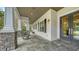 Welcoming front porch with gray tile flooring, elegant columns, and views of the lush landscaping at 6050 Saddle Oak Trl, Sarasota, FL 34241