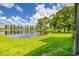 Lush green lawn leading to a serene lake with a fountain and backdrop of condo buildings at 6188 80Th N St # 102, St Petersburg, FL 33709