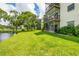 Scenic backyard with green grass, a pond, and condo buildings in the background at 6188 80Th N St # 102, St Petersburg, FL 33709