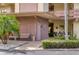 Building entryway featuring a bench, tropical landscaping, and a well-maintained exterior at 6188 80Th N St # 102, St Petersburg, FL 33709