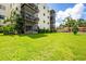 Condo building with green lawn, balconies, and lush landscaping at 6188 80Th N St # 102, St Petersburg, FL 33709