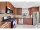 Galley kitchen featuring granite countertops, stainless steel appliances, and tile floors at 6188 80Th N St # 102, St Petersburg, FL 33709