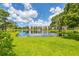 Scenic view of a pond reflecting a pristine condo building surrounded by lush green landscape on a sunny day at 6188 80Th N St # 102, St Petersburg, FL 33709