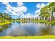 Scenic view of a large pond in front of pristine condo building surrounded by lush trees and blue skies at 6188 80Th N St # 102, St Petersburg, FL 33709