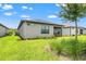 Manicured backyard with lush green grass, landscaping, and a covered patio perfect for outdoor enjoyment at 6612 Silverstar Dr, Sarasota, FL 34240