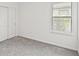A carpeted bedroom with a window and sliding door closet at 6612 Silverstar Dr, Sarasota, FL 34240