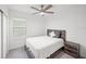 A well-lit bedroom featuring a queen-size bed, nightstand, window, and a ceiling fan at 6612 Silverstar Dr, Sarasota, FL 34240