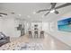 Open-concept living room and kitchen featuring an island with seating and modern appliances, plus a ceiling fan at 6612 Silverstar Dr, Sarasota, FL 34240