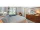 Bright bedroom with a view, chair with footstool, dresser with decor, and a large area rug at 6905 Pine Valley St, Bradenton, FL 34202