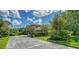 Charming home showcasing a large front yard with manicured landscaping, mature trees, and an ample driveway at 6905 Pine Valley St, Bradenton, FL 34202