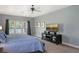 This main bedroom features soft blue walls, ceiling fan, access to the screened lanai, and television at 6905 Pine Valley St, Bradenton, FL 34202