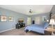 This spacious main bedroom features soft blue walls, a ceiling fan, and a large television for viewing at 6905 Pine Valley St, Bradenton, FL 34202