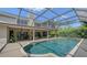 Back exterior featuring a large screened-in pool, patio, and manicured lawn ideal for relaxation and outdoor entertainment at 6905 Pine Valley St, Bradenton, FL 34202
