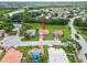 Aerial view of a single-Gathering home with a red tile roof nestled in a peaceful neighborhood with a nearby lake at 7115 39Th E Ln, Sarasota, FL 34243
