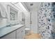 Well-lit bathroom with a blue floral shower curtain and neutral colored floors at 7115 39Th E Ln, Sarasota, FL 34243
