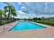 A serene community pool area with palm trees and a lake view, perfect for relaxation and recreation at 7115 39Th E Ln, Sarasota, FL 34243