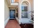 Inviting entrance with a blue door, sidelight windows, and lush landscaping, creating a warm welcome at 7115 39Th E Ln, Sarasota, FL 34243