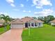 Charming single-story home boasts a red tile roof, lush landscaping, and a spacious two-car garage at 7115 39Th E Ln, Sarasota, FL 34243
