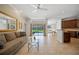 Open-concept living area features tile flooring, a comfortable sofa, and views of the pool area at 7115 39Th E Ln, Sarasota, FL 34243