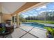 Covered lanai with a grill, seating, and views of the pool, extending the living space outdoors at 7115 39Th E Ln, Sarasota, FL 34243