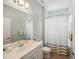 Bathroom with a white vanity, large mirror, and a shower with a striped curtain at 7130 Westhill Ct, Lakewood Ranch, FL 34202