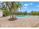 A large community pool is surrounded by a spacious deck and palm trees for a resort-style living experience at 7130 Westhill Ct, Lakewood Ranch, FL 34202