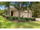 Charming single-story home with a well-manicured lawn and tropical landscaping at 7130 Westhill Ct, Lakewood Ranch, FL 34202