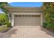 Two-car garage with brick paver driveway and exterior lighting at 7130 Westhill Ct, Lakewood Ranch, FL 34202