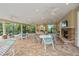 Outdoor lounge area featuring multiple tables, a stone fireplace, ceiling fans, and comfortable seating for relaxation at 7130 Westhill Ct, Lakewood Ranch, FL 34202
