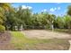 Outdoor sand volleyball court surrounded by lush landscaping and a black metal fence on a bright, sunny day at 7130 Westhill Ct, Lakewood Ranch, FL 34202