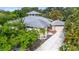 Aerial view of a unique home with mature landscaping, a gray roof, and a circular tower at 7615 4Th Avenue Nw Dr, Bradenton, FL 34209