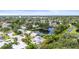 Aerial view of a residential area with mature trees, a pond, and well-maintained homes at 7615 4Th Avenue Nw Dr, Bradenton, FL 34209