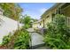 Backyard view featuring a wooden walkway through tropical landscaping on a sunny day at 7615 4Th Avenue Nw Dr, Bradenton, FL 34209