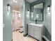 Light blue bathroom features a modern vanity and sink, decorative mirror, and shower with tiled flooring at 7615 4Th Avenue Nw Dr, Bradenton, FL 34209