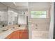 Bright bathroom features a large mirror, orange cabinets, and marble countertops for a unique style at 7615 4Th Avenue Nw Dr, Bradenton, FL 34209