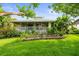 Exterior featuring a screened porch with landscaped garden and beautiful greenery at 7615 4Th Avenue Nw Dr, Bradenton, FL 34209