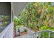 Inviting front porch with lush tropical landscaping and a serene outdoor seating area at 7615 4Th Avenue Nw Dr, Bradenton, FL 34209
