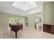 Open living room with a skylight, a piano, and access to the lanai through sliding doors at 7615 4Th Avenue Nw Dr, Bradenton, FL 34209
