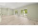 Open living room with sleek wood floors, sliding doors to the lanai, and natural light at 7615 4Th Avenue Nw Dr, Bradenton, FL 34209