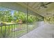 Covered porch features a ceiling fan, screened panels, and views of a picturesque landscaped yard with pond at 7615 4Th Avenue Nw Dr, Bradenton, FL 34209