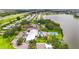 Expansive aerial view showcases the community clubhouse, pool, tennis court, and nearby lake at 8470 Imperial Cir, Palmetto, FL 34221
