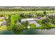 Picturesque aerial view of a clubhouse with a pool and hot tub overlooking a serene lake at 8470 Imperial Cir, Palmetto, FL 34221
