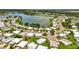 Aerial view featuring a lake, mature trees, and tidy homes in a friendly neighborhood setting at 8470 Imperial Cir, Palmetto, FL 34221