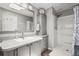 Bright bathroom features a shower, a toilet, a sink, framed mirror, and cabinetry for storage at 8470 Imperial Cir, Palmetto, FL 34221