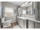 Bright bathroom features a window, a toilet, a sink, framed mirror, and cabinetry for storage at 8470 Imperial Cir, Palmetto, FL 34221