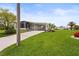 Exterior shot showcases a single-story home with well-kept lawn, covered carport, and established landscaping at 8470 Imperial Cir, Palmetto, FL 34221