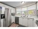 Kitchen showcasing stainless steel appliances, white cabinets, and laminate flooring at 8470 Imperial Cir, Palmetto, FL 34221