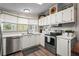 Well-lit kitchen with stainless steel appliances, white cabinetry and laminate flooring at 8470 Imperial Cir, Palmetto, FL 34221