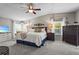 This primary bedroom features a ceiling fan, carpeted floor, bedside tables with lamps, and large dresser at 8470 Imperial Cir, Palmetto, FL 34221